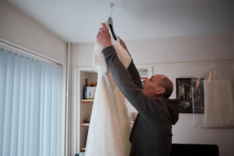 De trouwjurk wordt van de hanger gehaald