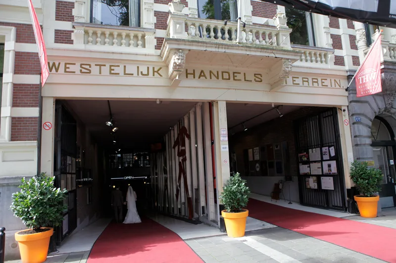 De bruid loopt over de rode loper door de ingang van het Westelijk Handelsterrein