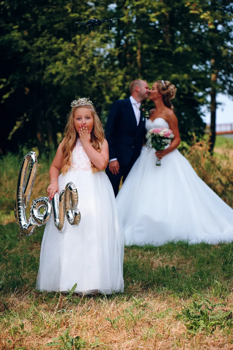 Het nichtje van Marcella met een ‘love’-ballon, Kevin en Marcella kussen erachter