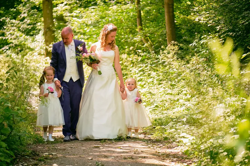 Chantal en Ramon lopen met twee meisjes in witte jurkjes over een zonnig pad