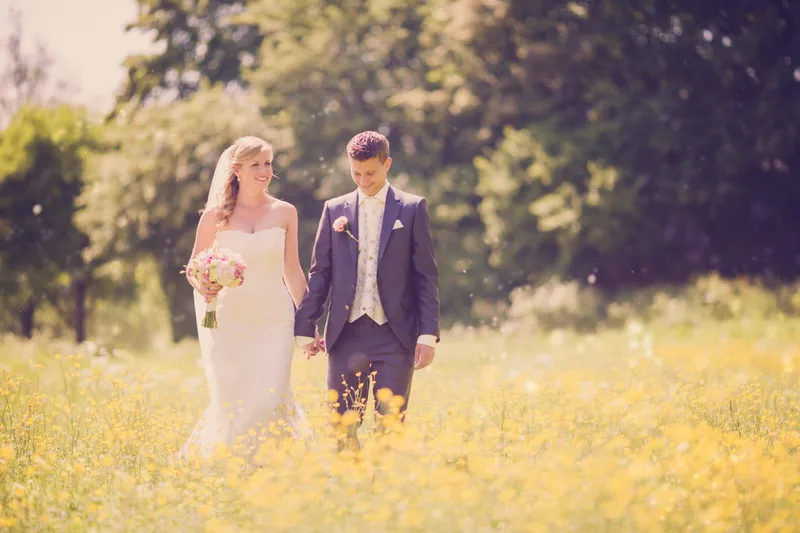 Nienke en Vincent lopen door het veld met boterbloemen
