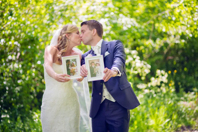 Nienke en Vincent kussen achter twee fotolijstjes