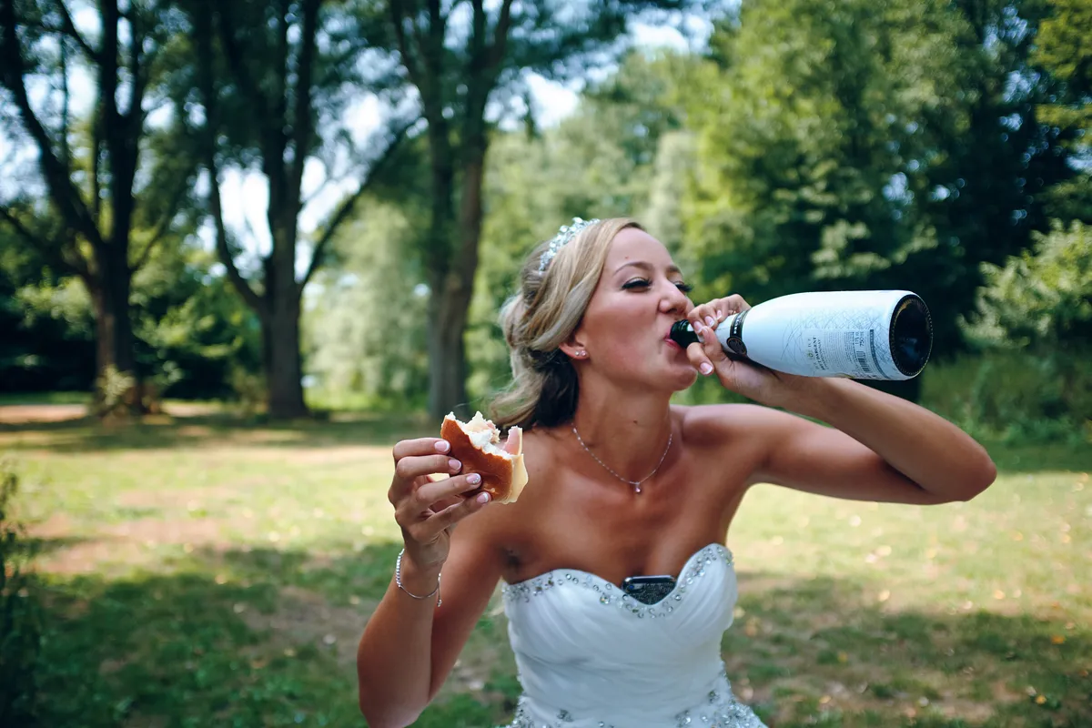 Marcella neemt een slok uit een fles bubbels in het park