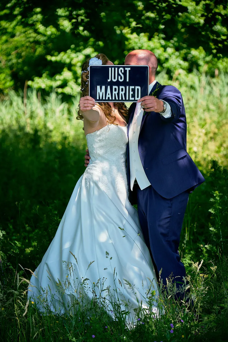 Chantal en Ramon houden een Just Married-bordje voor hun gezicht