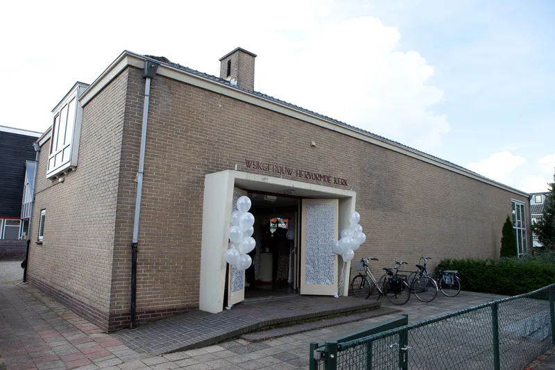 Het wijkgebouw van de kerk, met witte ballonnen bij de deur