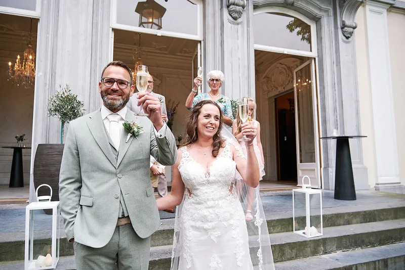 Romana en Sander proosten op de trap van het landhuis