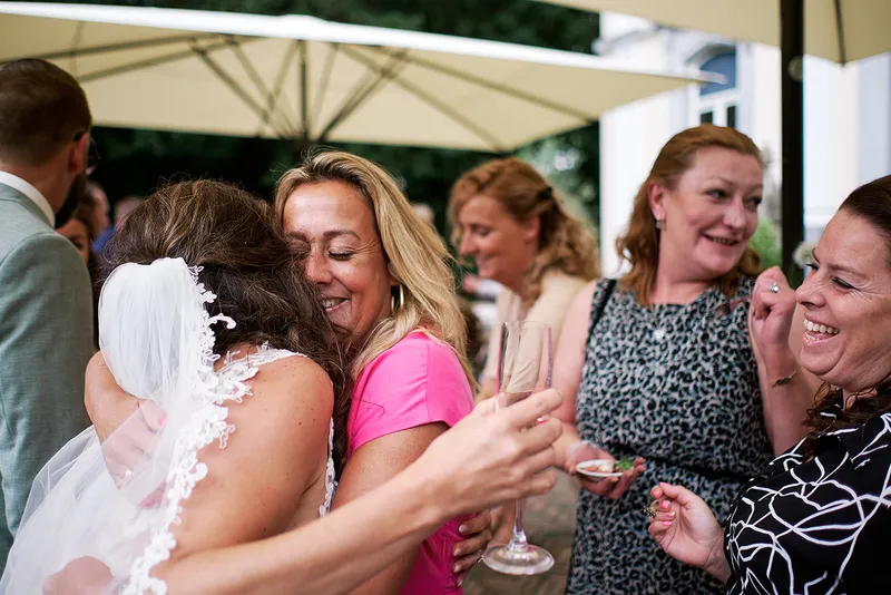Romana wordt geknuffeld door vriendinnen bij de felicitaties