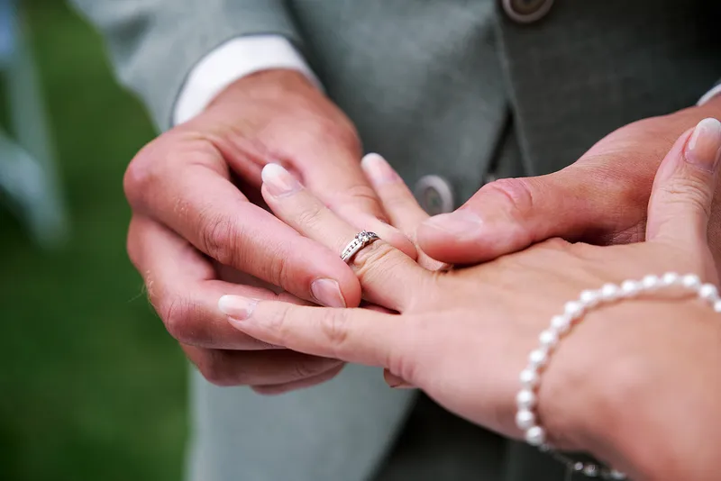 Close-up: Sander schuift de ring om de vinger van Romana