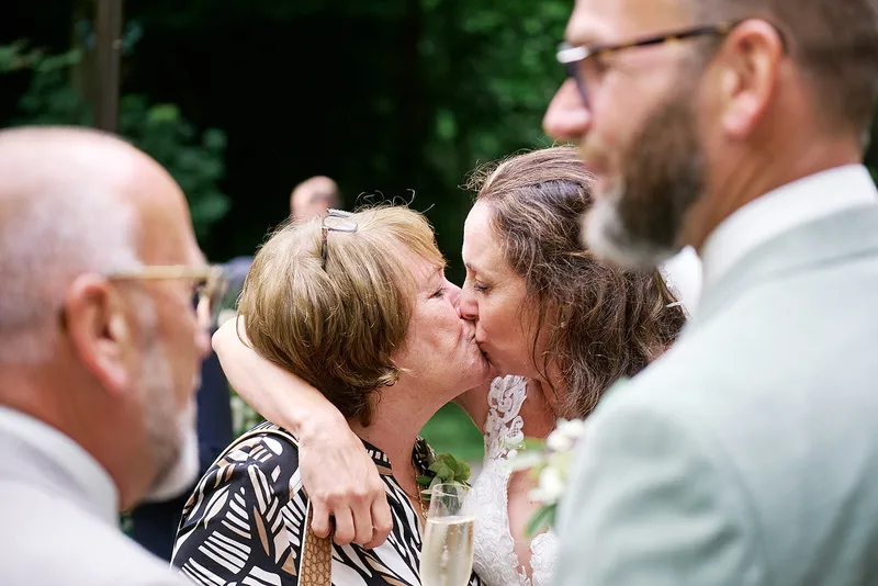 Een gast geeft Romana een kus bij de felicitaties