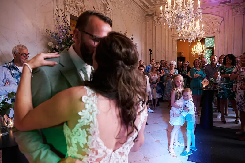 Romana en Sander dansen in de zaal met kroonluchters en gekleurd licht