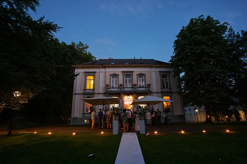 Het landhuis van Wolfslaar in de avond, met lichtjes langs de witte loper