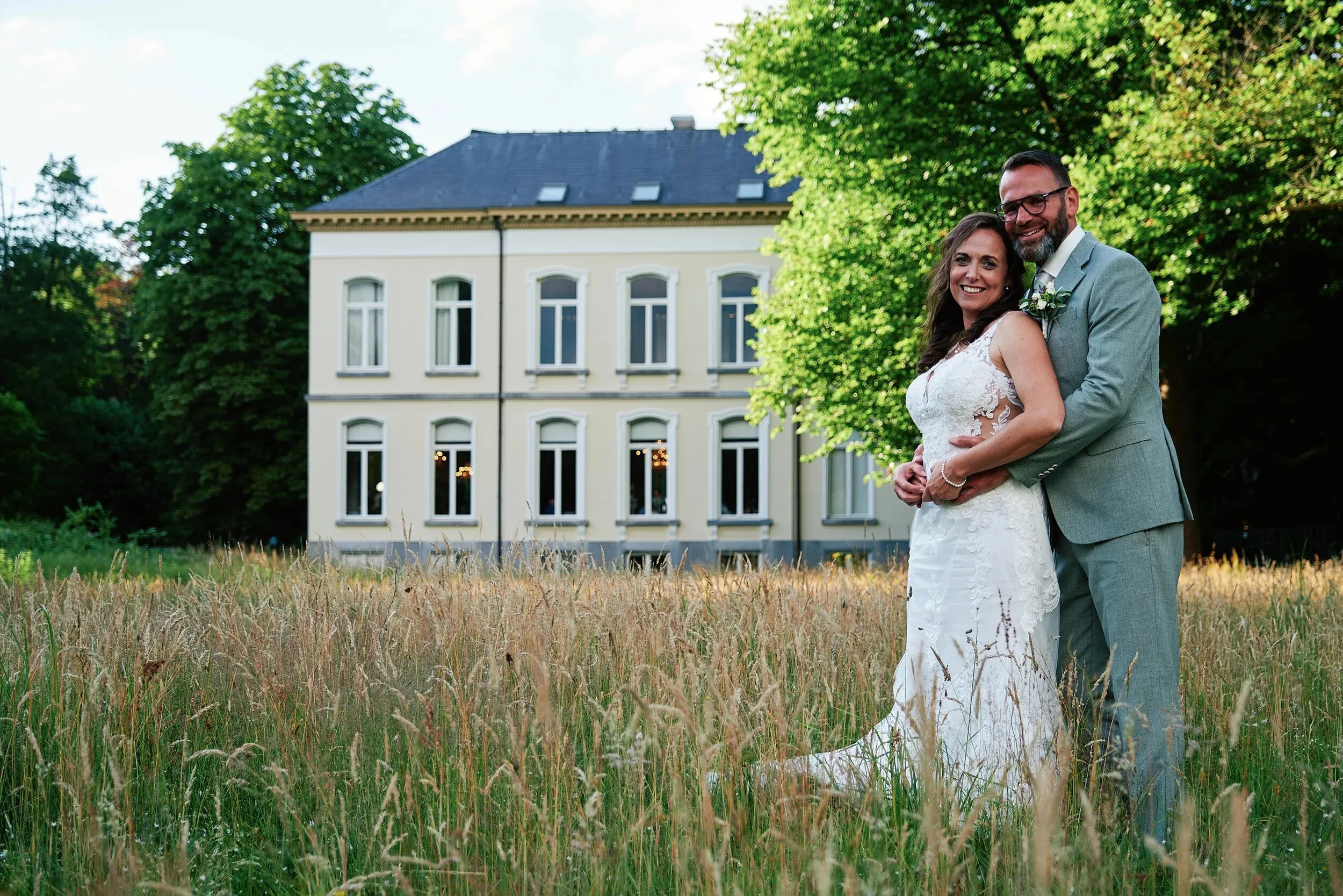 Romana en Sander in het hoge gras voor het landhuis van Landgoed Wolfslaar in Breda