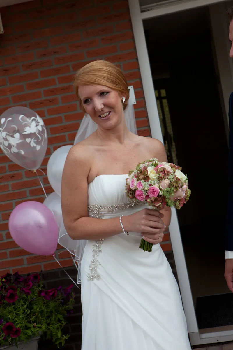 Jorike bij de roze ballonnen voor de deur