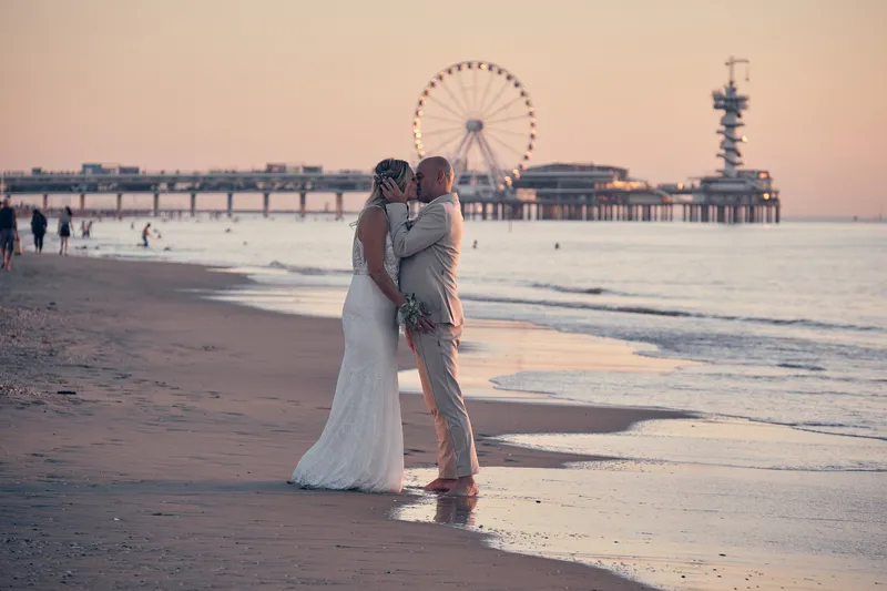 Jolanda en Pascal op het strand, met de pier en het reuzenrad