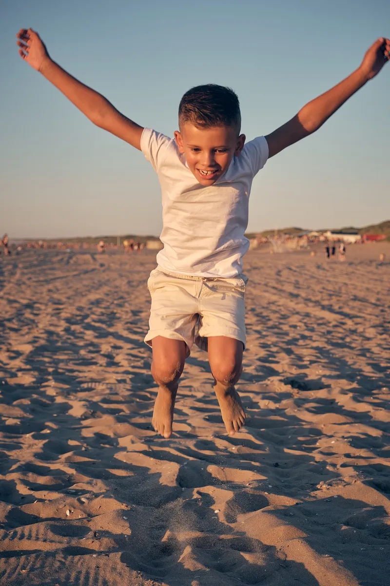 Pascals zoon springt hoog op in het zand